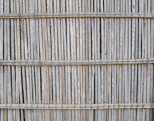 Old faded fence made of reeds as a background or backdrop