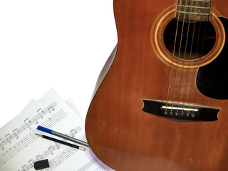 acoustic guitar is used composing note song with pen pencil ruber isolated white background