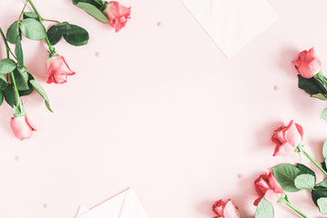 Flowers composition. Pink rose flowers, envelopes on pastel pink background. Valentines day, mothers day, womens day concept. Flat lay, top view, copy space