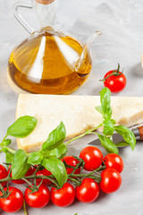 Bunch of fresh basil, tomatoes, parmesan cheese, garlic and olive oil - traditional ingredient of italian cuisine
