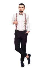 Fototapeta premium stylish young bearded guy in shirt, pants and suspenders posing on a white background