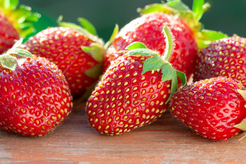 Close view of red ripe strawberries on wooden surface. Strawberry close-up