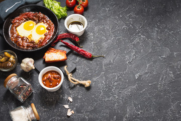 Shakshuka, Fried Eggs in Tomato Sauce in iron frying pan. Typical Israel food.
