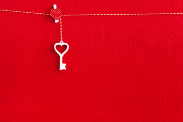Close up of White wooden key on red paper background.