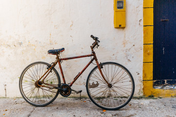 Fototapeta na wymiar Old rustic vintage bicycle on the street near the color wall. Travel concept. Bike ride. Postcard. Copy space.