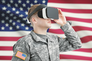 Indoors shot of USA soldier wearing VR glasses with American flag on background
