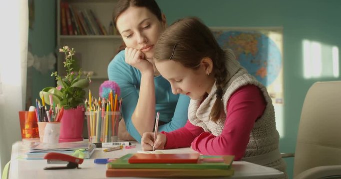 Attractive Parent Mother Helping to Do Homework to Little Student School Girl