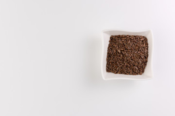 Flax seeds in bowl isolated on white background