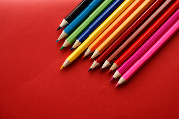 Coloured pencils isolated on the red background