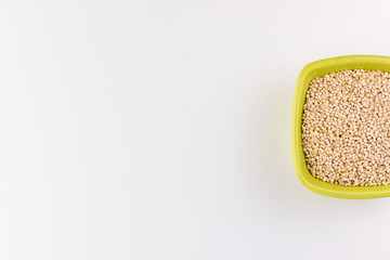 Quinoa in ceramic cup isolated on white background. Raw white quinoa