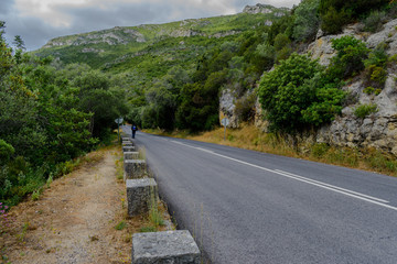 Man walking in the Arrábida Mountain Natural Park with mountain in the background, Setúbal - Portugal
