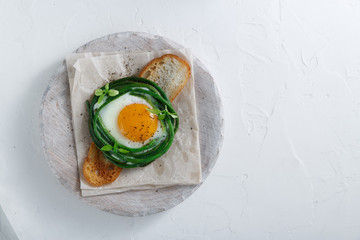 Fried egg with grean beans on toasted bread, copy space
