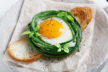 Sunny side fried egg with green beans and toasted bread