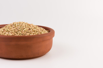 Natural fresh green buckwheat in bowl isolated on white background.