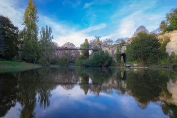 Obraz premium Paryż, Francja - 11 03 2018: Sąsiedztwo Villette. Park Buttes-Chaumont. Wyspa z mostem i odbija się na wodzie