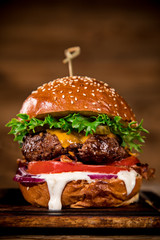 Tasty burger on wooden table. © Lukas Gojda