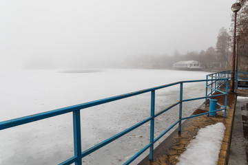 Plakat Standing at the Frozen Lake on a Foggy Winter Day