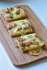 Bread tartines with tuna flakes and melted mozzarella