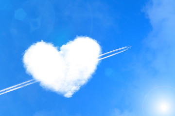 The plane pierces a cloud of heart like an arrow of cupid. Valentine's Day Concept