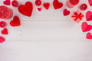 Valentines day romantic decoration with hearts and candles on a white wooden table. Top view, copy space.