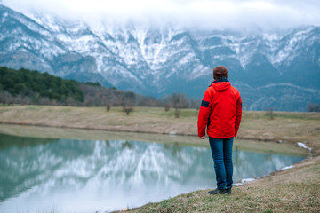 A young tourist looks at the picturesque landscape of snow-cappe