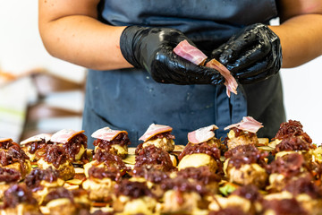 Female Chef Putting Ingredients of Burgers on a Sliced Bread Spread on a Table in Black Gloves - Concept of the Hard Working Person and the Hygiene in the Kitchen