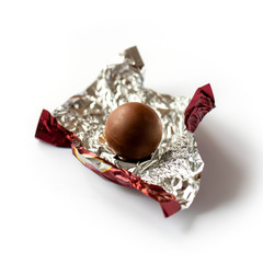 Chocolate praline wrapped in foil. Isolated on white background