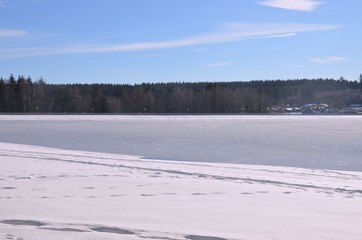 Fototapeta na wymiar Winterlandschaft am vereisten See sonnig - Wintersport