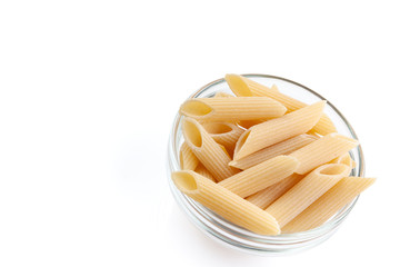 Raw feathers macaroni in bowl. Italian pasta close up, isolated on the white background