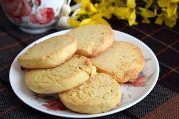 Delicious homemade cookies with lemon zest. Round cookies are stacked on top of each other on a plate. Close-up, homemade cakes in a white plate on a table with a tablecloth