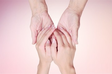 Hands of the old man and a young woman. close up.