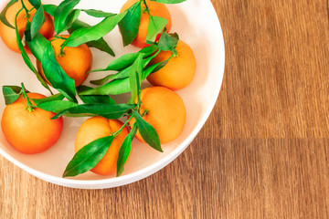 Fresh picked mandarins on a brown wooden table