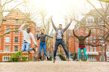 Group of happy friends jumping together at park