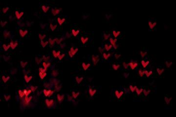 Naklejka na ściany i meble Red heart valentine bokeh lights against a black background
