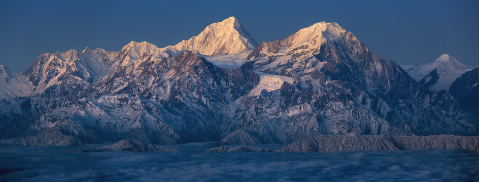 Minya Konka (Mount Gongga) view from Niubeishan Cattle Back Mountain in Sichuan Province, China. Summit shrouded in clouds. Highest Mountain in Sichuan Province China. Twilight moonlit landscape