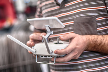 Man hands holding transmitter and controlling FPV drone 3
