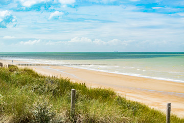 Beach, summer and paysage concept: view of the beach, vegetation on the dunes and wooden breakwater on the north sea.Oye-Plage in France.