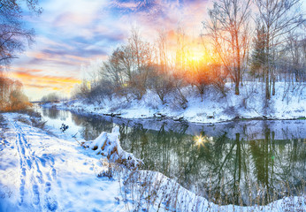 Winter landscape by a river in the sunset