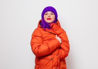 Beautiful young girl with purple hair and in orange jacket on white background.