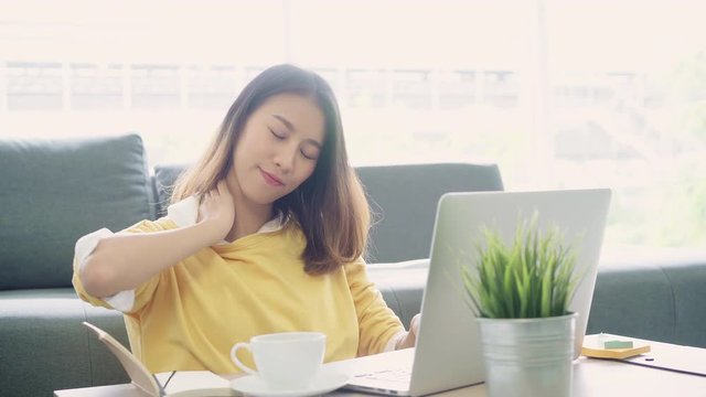 Business freelance woman stretching her body because feel tired after working on laptop, smart female working at home. Lifestyle women relax after working at home concept.