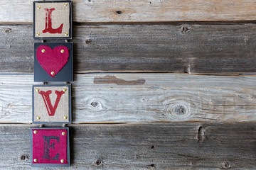 The word LOVE down side of image on wood background