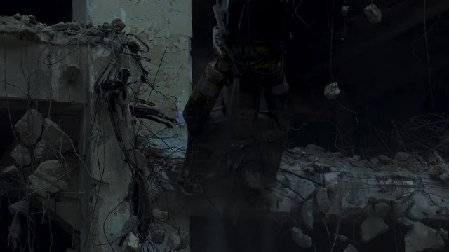 Demolishing of a building,Demolition tongs on an excavator on a construction site.