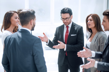 close up.a group of employees talking standing in a circle