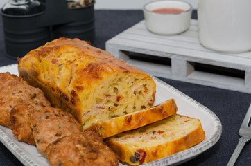 Tray of appetizers meatballs and savory bread with bell pepper, herbs, cheese and olives. Rustic style. 