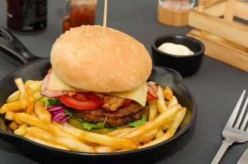 Homemade delicious hamburger served with french fries and sauce. Homemade cheeseburger. 
