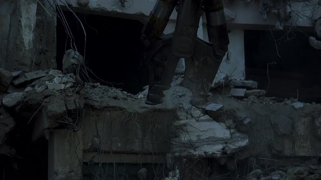 Demolishing of a building,Demolition tongs on an excavator on a construction site.