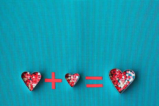 Three heart shaped cookie cutters over a blue background. - Powered by Adobe