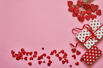 Valentines Day background. Red hearts and gift boxes on pink background. Copy space, top view