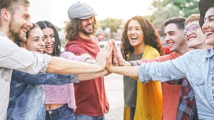 Group of diverse friends stacking hands outdoor - Happy young people having fun joining and celebrating together - Millennials, friendship, empowering, partnership and youth lifestyle concept - obrazy, fototapety, plakaty