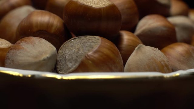 Hazel nuts in nutshell. Rotation. Closeup.    Walnuts in a bowl. Selective focus. Black background. Studio shot. Healthy food concept.